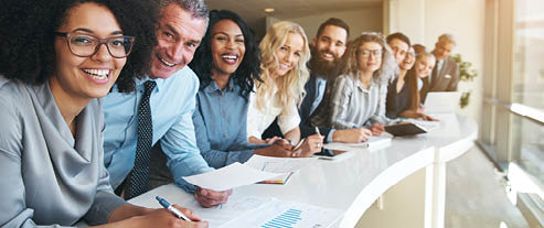 Smiling black and white coworkers looking at camera in the office 