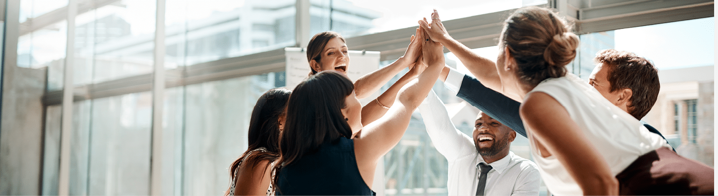Shot of a group of businesspeople high fiving while sitting in a meeting