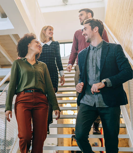 Group of diverse coworkers walking down the stairs in an office